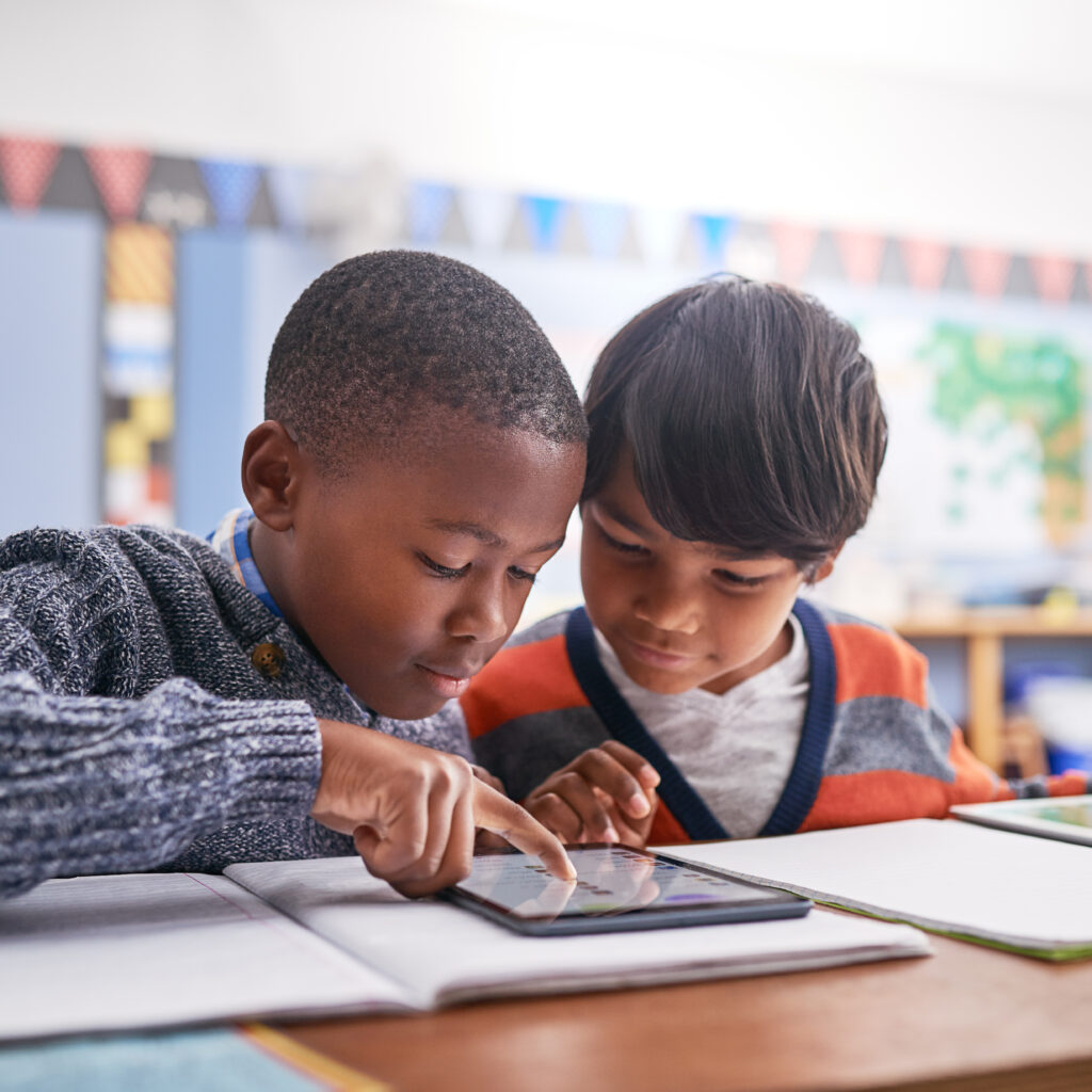 Together we will figure it out. Cropped shot of elementary school children using a tablet in class